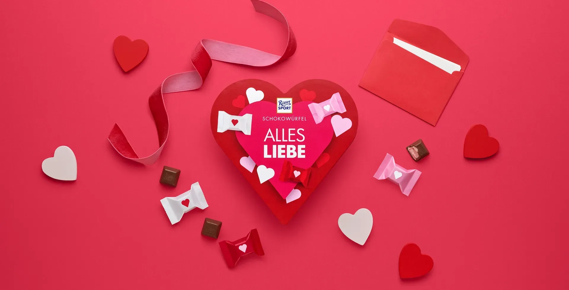 Verpackung einer blauen Schokoladentafel mit Nüssen, Schokoladenstückchen und dem Hinweis „55 % Kakaoanteil“ auf blauem Hintergrund