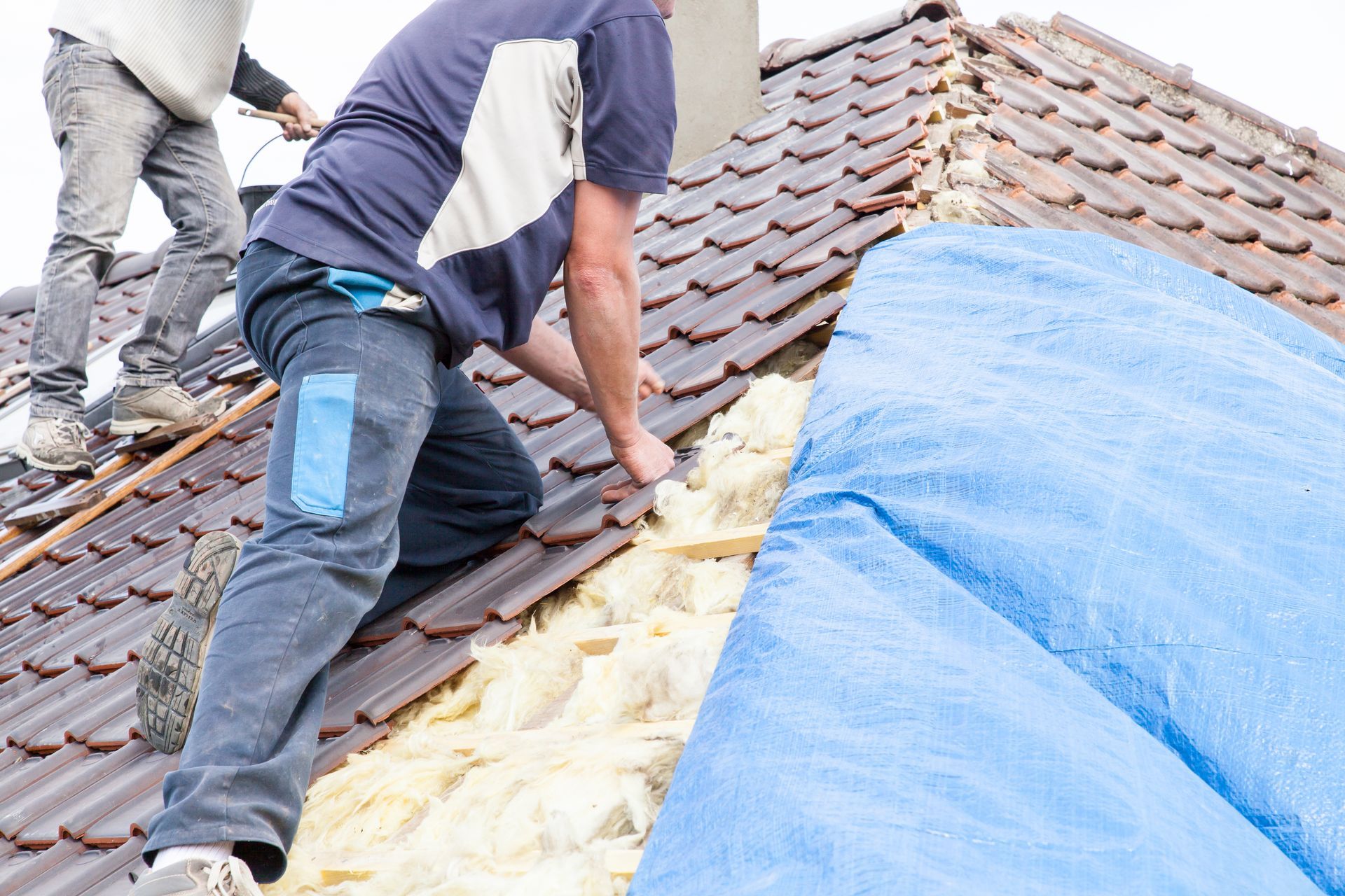 Two men are working on a roof for a Layton, Utah roofing company