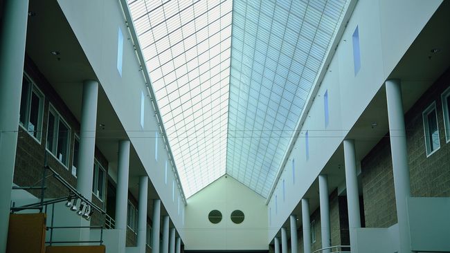 The inside of a building with columns and a skylight