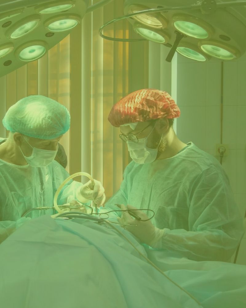 Two surgeons are operating on a patient in an operating room.