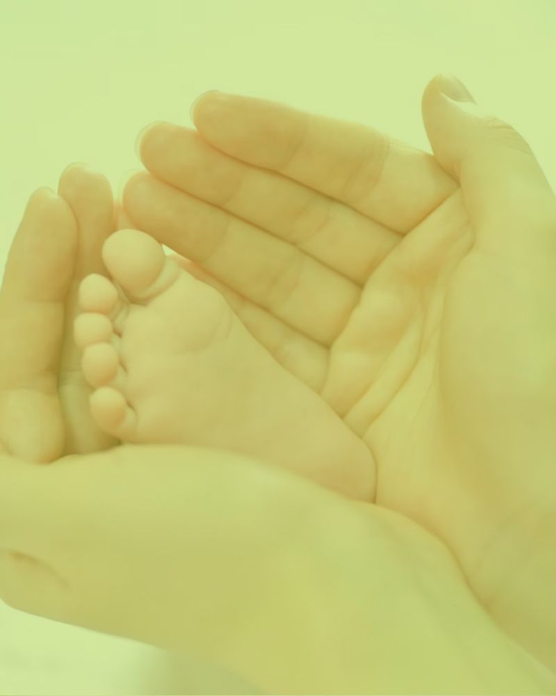 A person is holding a baby 's foot in their hands.