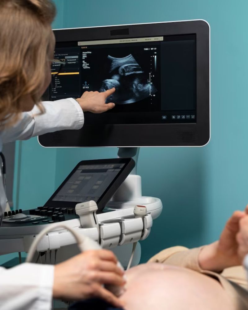 A pregnant woman is getting an ultrasound from a doctor