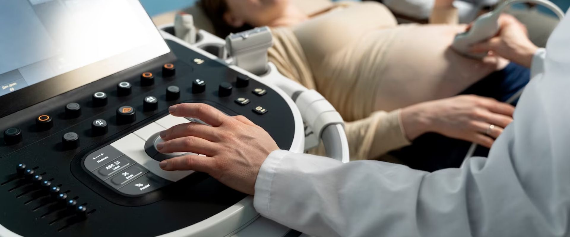 A pregnant woman is getting an ultrasound from a doctor.