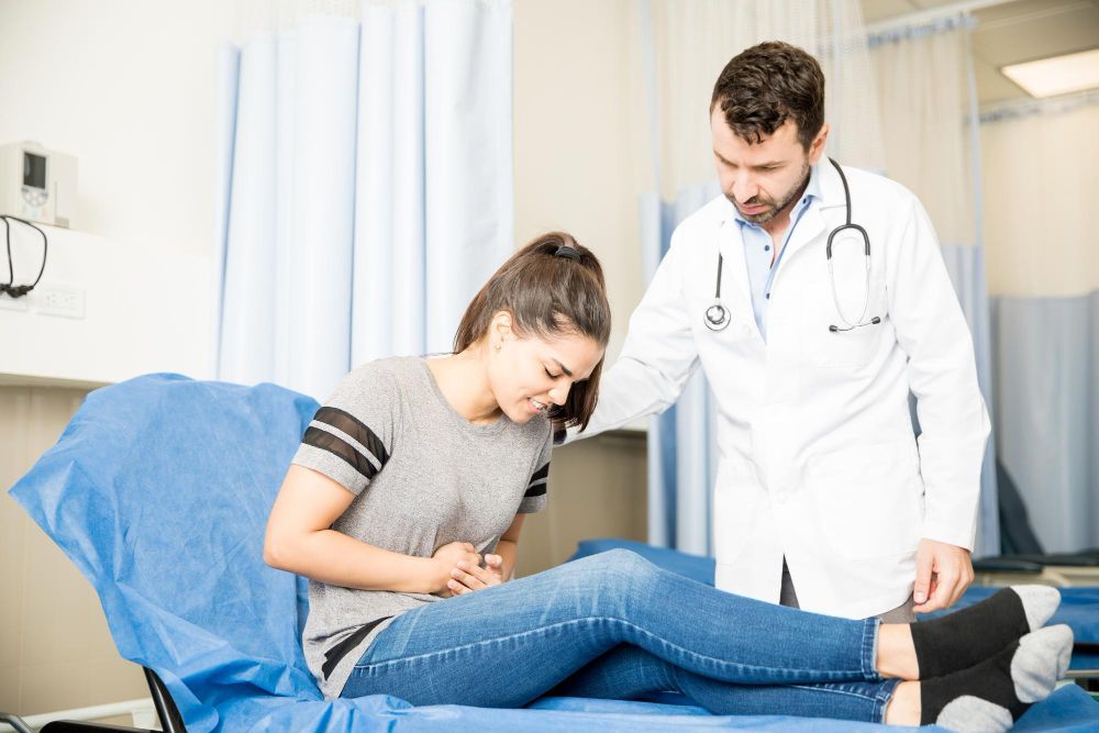 A doctor is talking to a patient who is laying in a hospital bed.