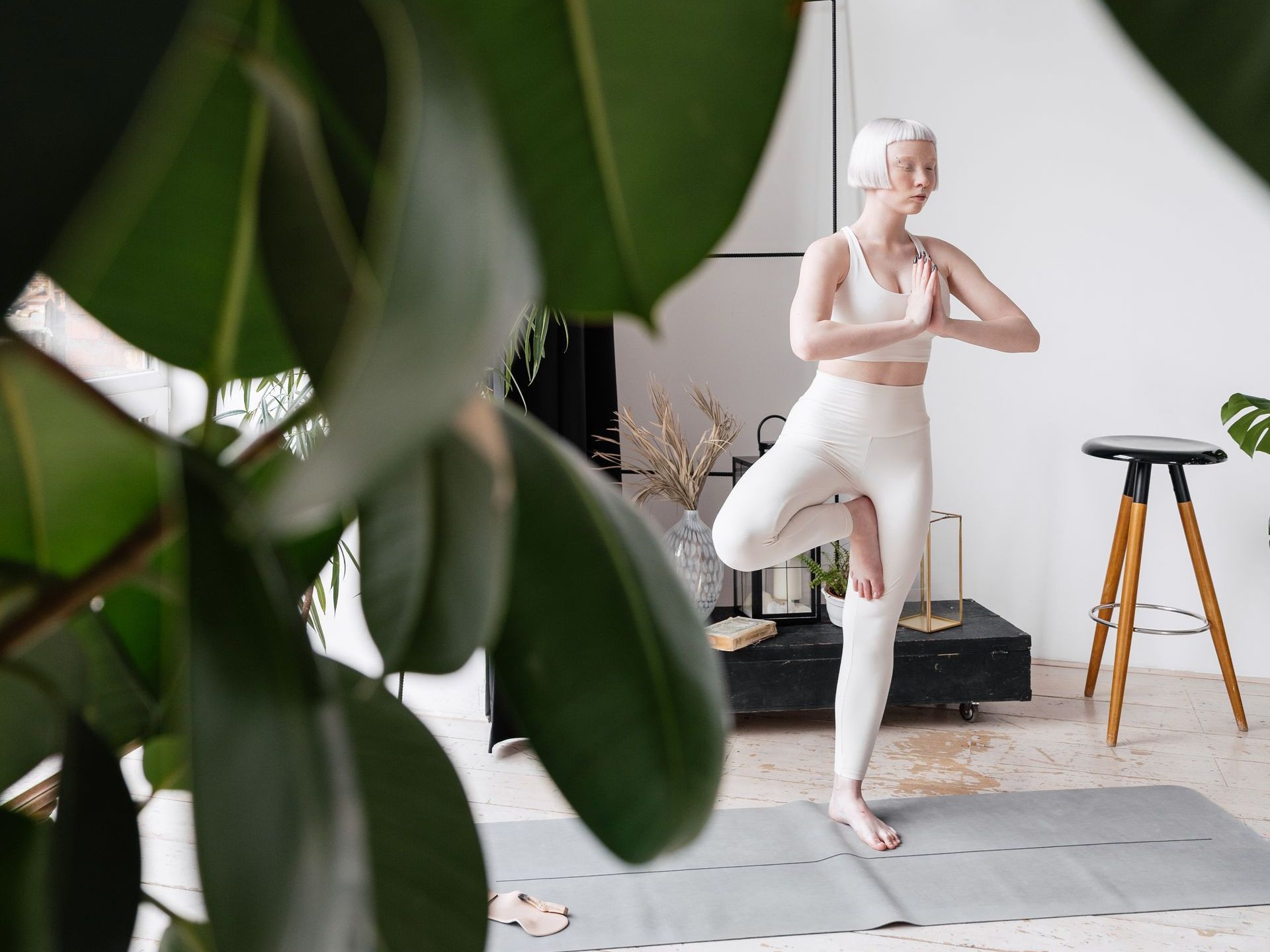A woman is practicing yoga on a mat in a living room.