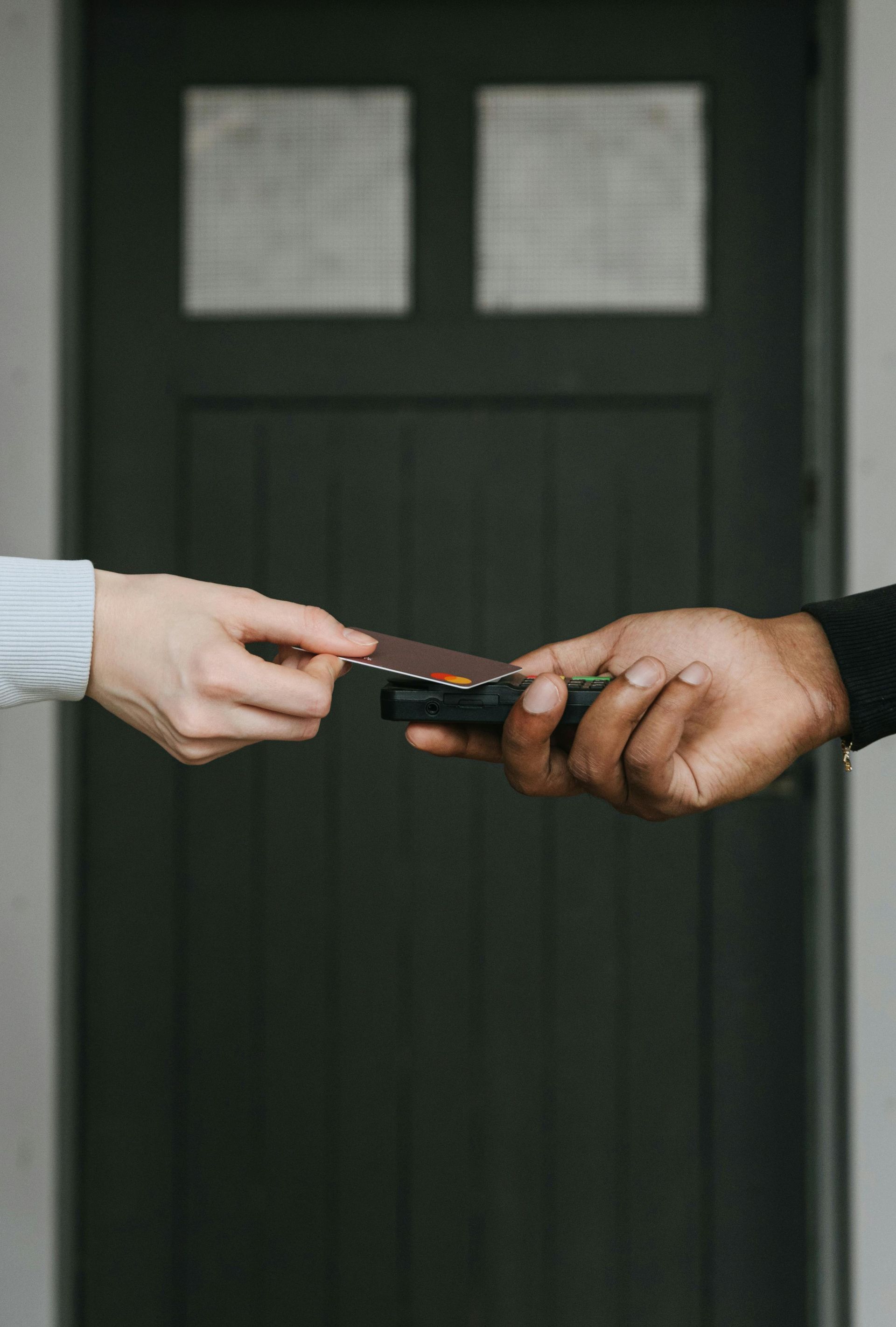 Hands exchanging a set of keys at a front door