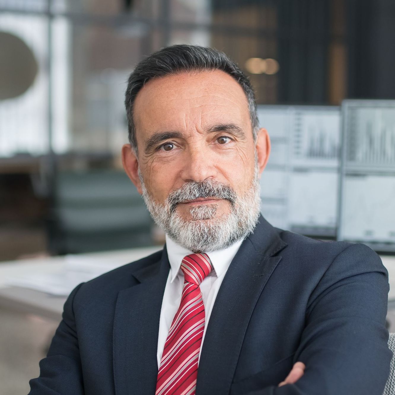 A man with a beard is wearing a suit and tie.