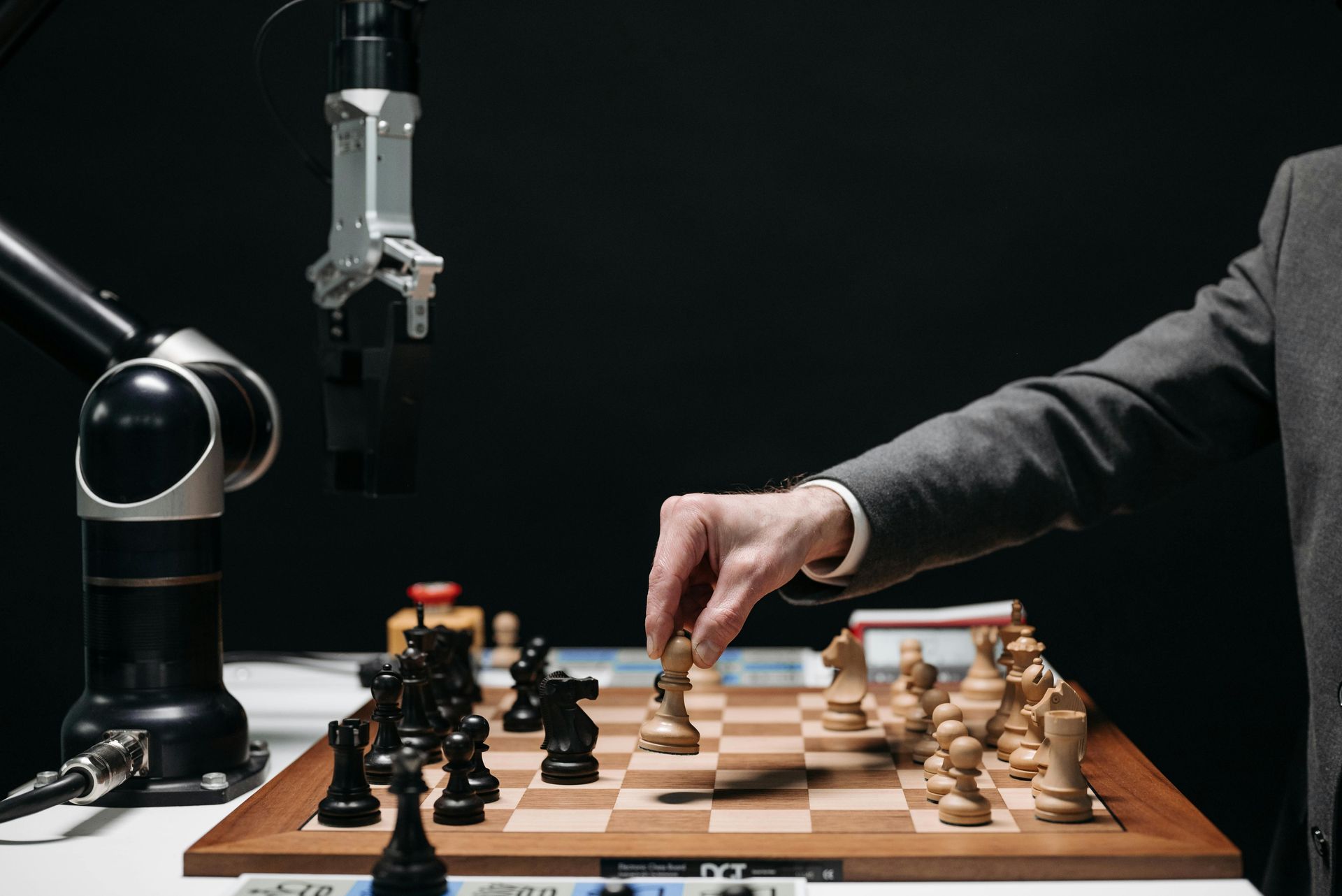 A man is playing a game of chess with a robot.