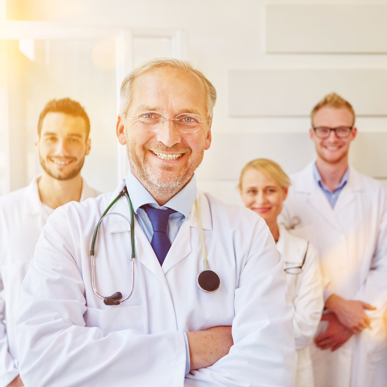 A group of doctors are posing for a picture in a hospital.