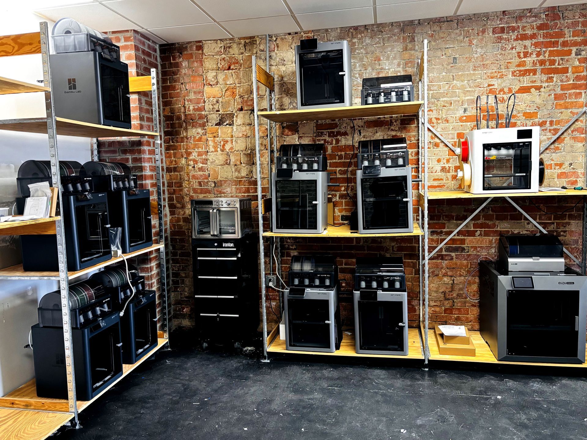Shelves of desktop computer towers in a brick-walled electronics workshop