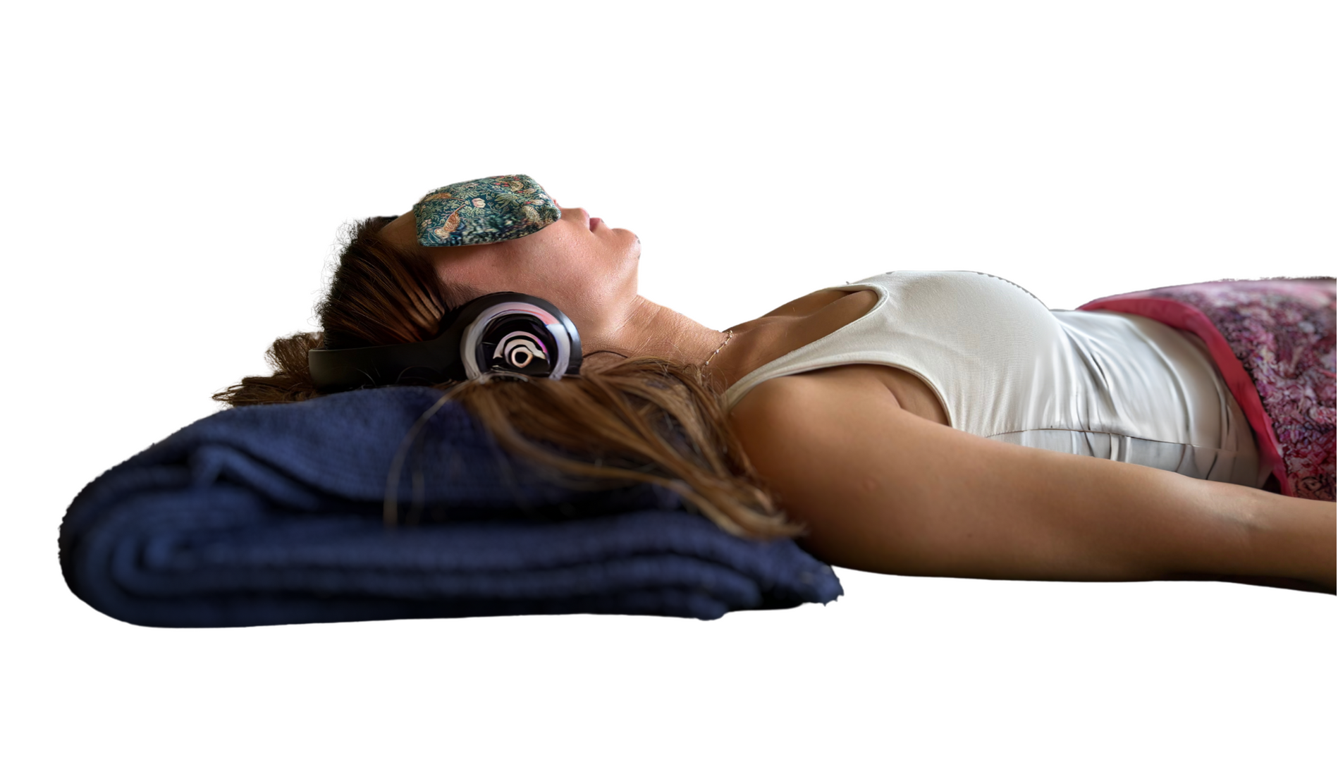 A woman is laying on the floor wearing headphones and an eye mask.