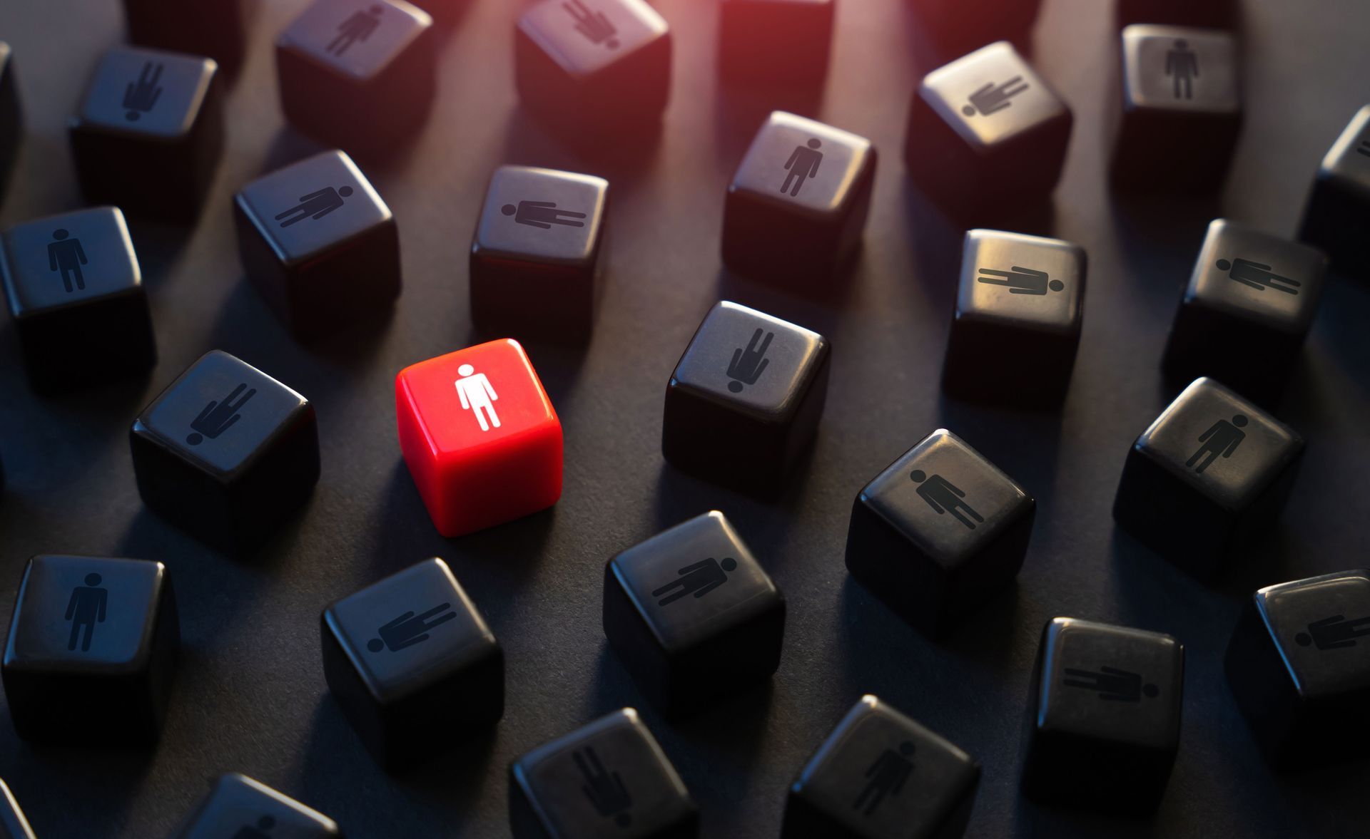 A red dice with a man on it is surrounded by black dice