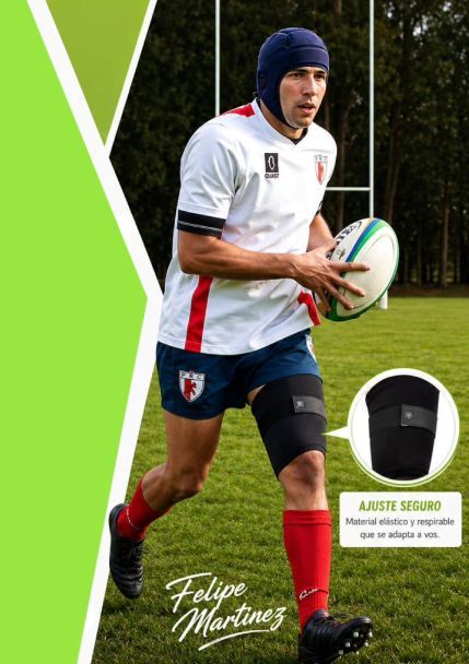 Jugador de rugby con camiseta blanca y medias rojas corriendo con un balón en el campo.