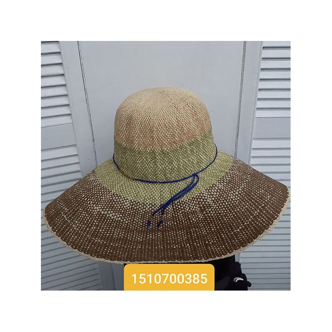 A straw hat with a blue ribbon around the neck is sitting on a table.
