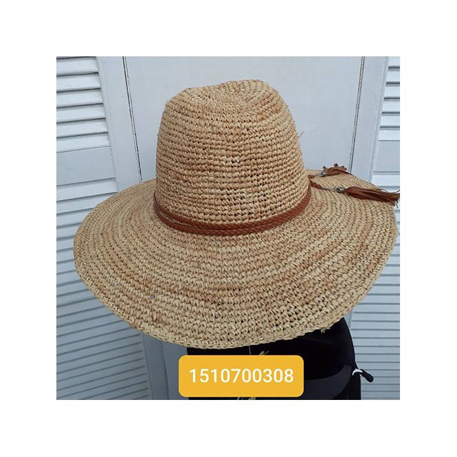 A woman is wearing a straw hat with a brown strap.