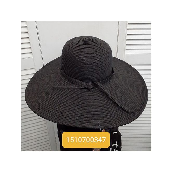 A woman is wearing a black hat with a bow.