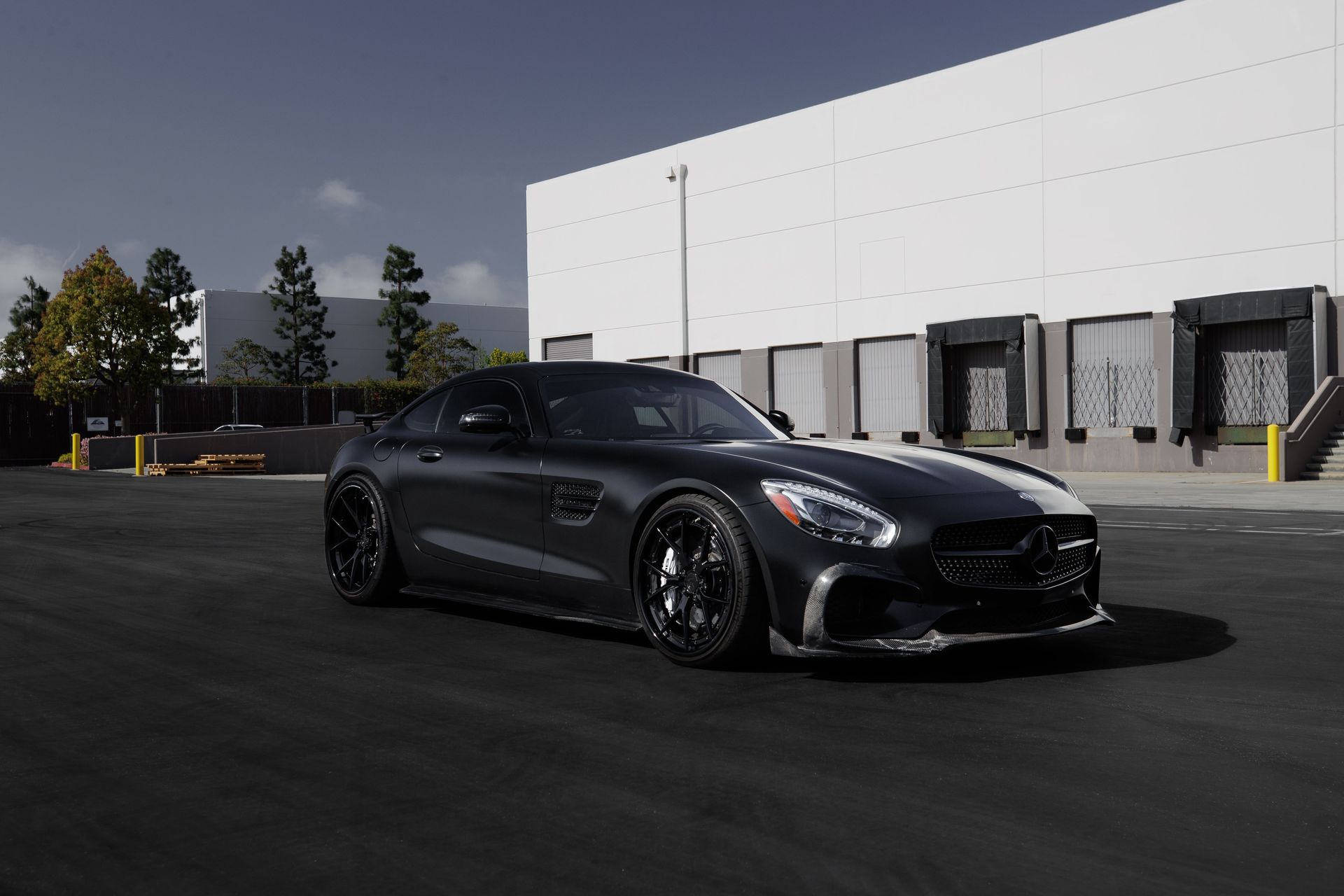 a black sports car is parked in front of a large white building .