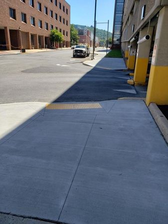 A car is parked on the side of the road in front of a building