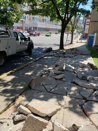A truck is parked on the side of the road next to a pile of concrete.