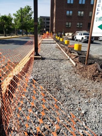 A construction site with a brick building in the background