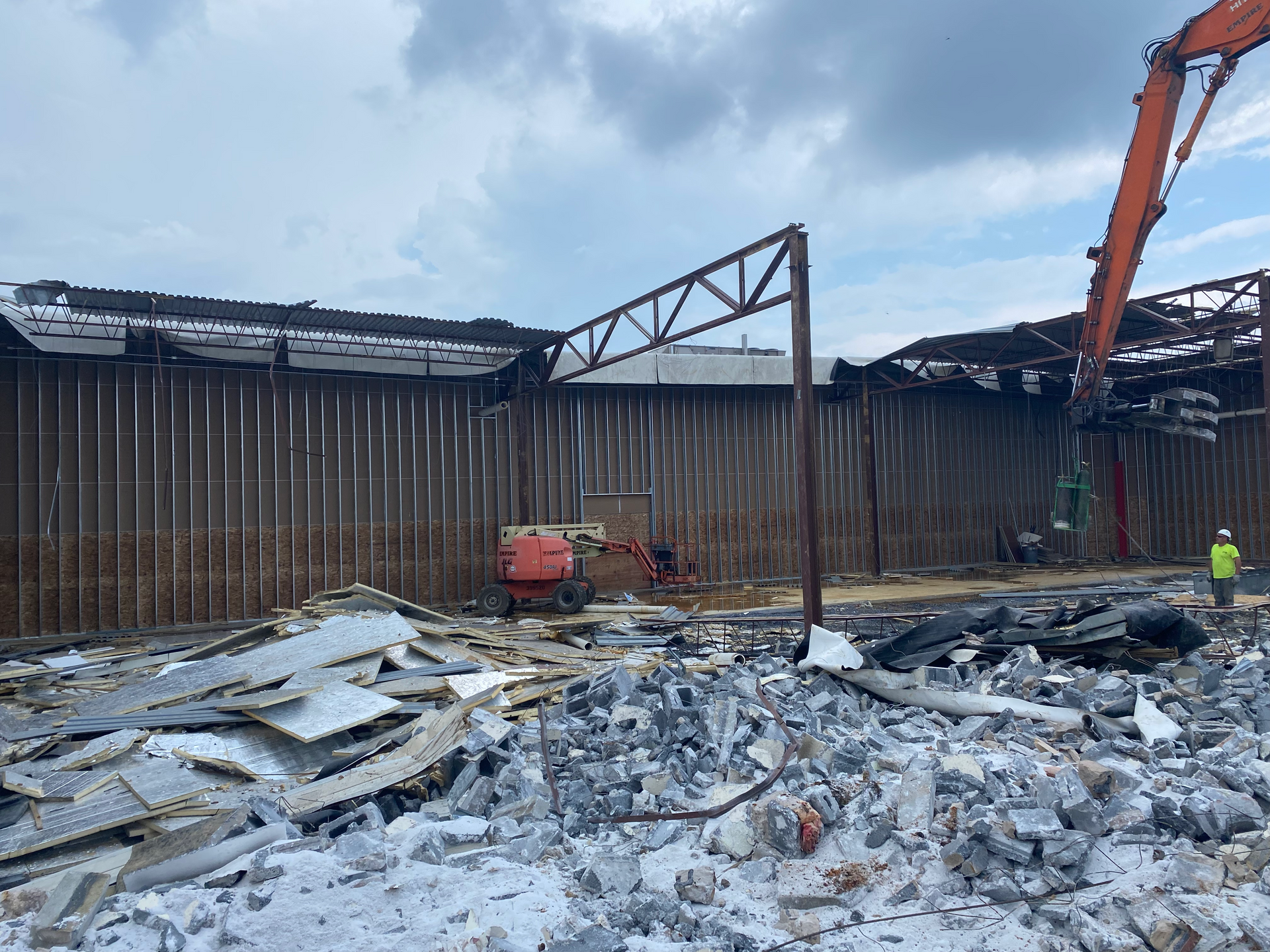 A large building is being demolished in the snow.