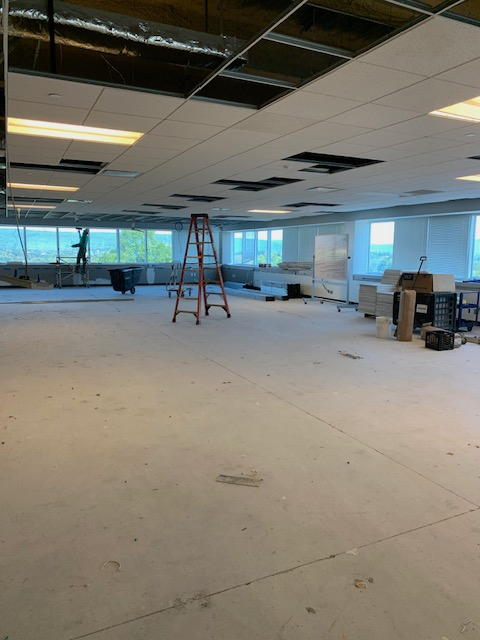 A large empty room with a ladder in the middle