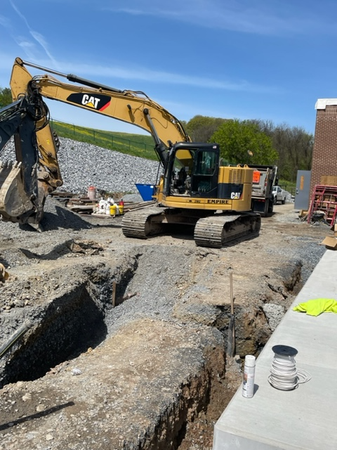 A cat excavator is digging a hole in the ground