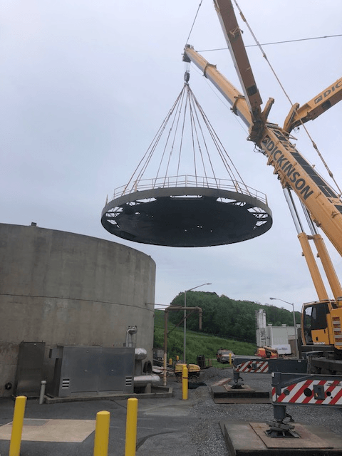 Removing a digester lid.