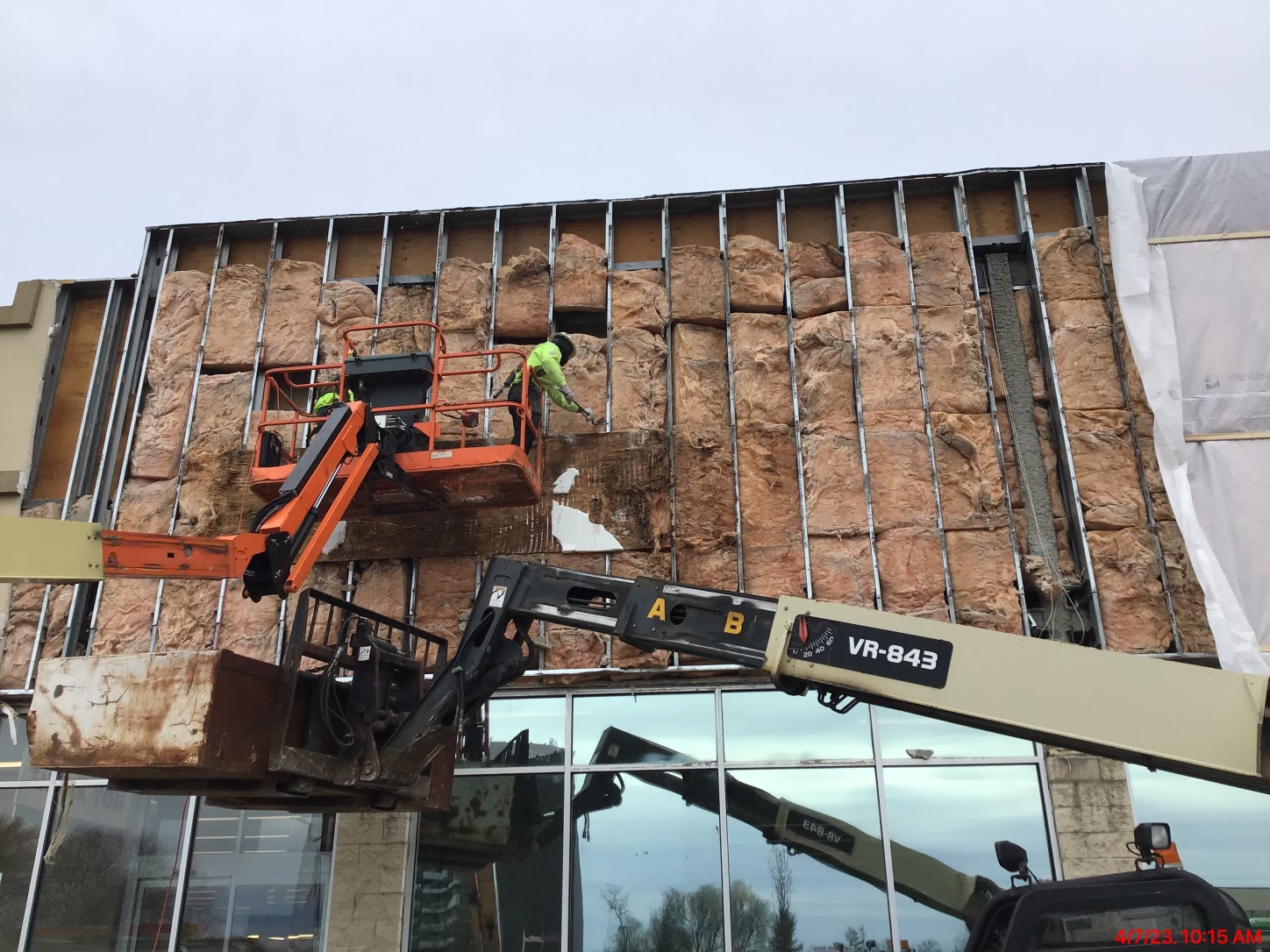 A large building is being demolished by a crane.