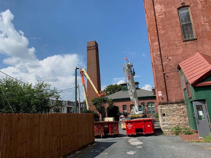 A red truck is parked in front of a brick building