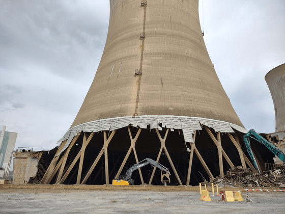 A large cooling tower that is being demolished