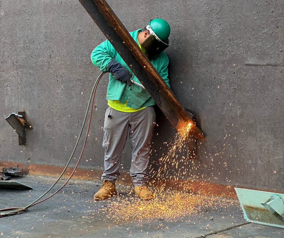 One of Empire Services' crew torch cutting a piece of metal frame in the clarifier.