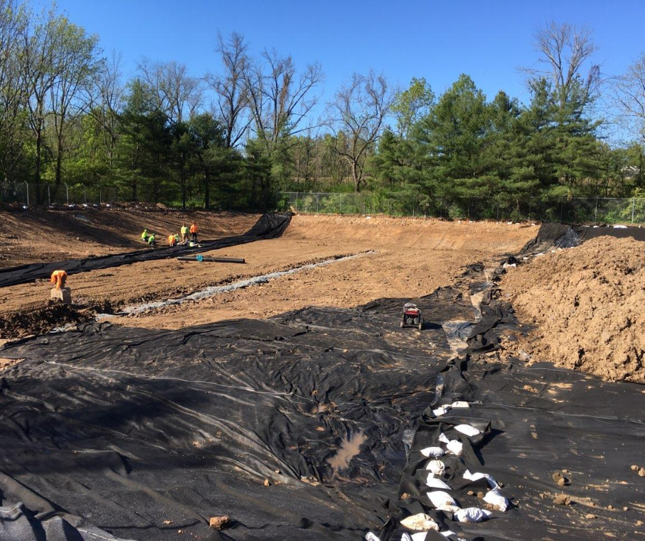 A construction site with a lot of dirt and trees in the background.