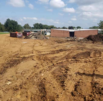 A construction site with a brick building in the background