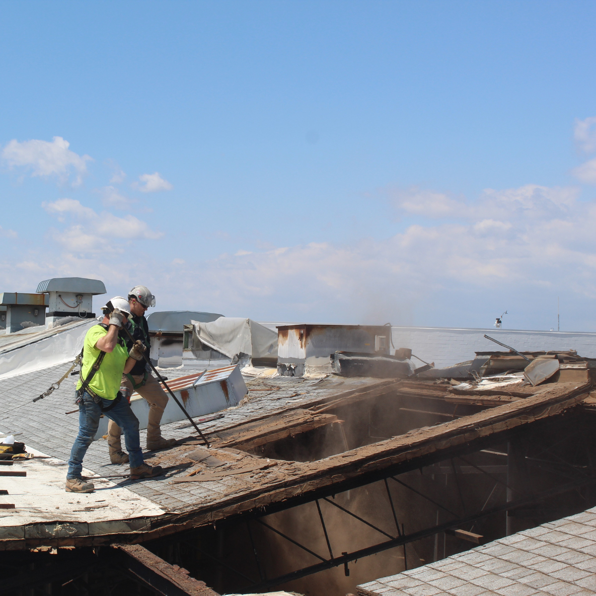 Empire Services crew members hand demolish the roof.