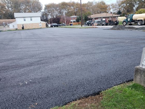 A large asphalt parking lot with a truck parked in the background.