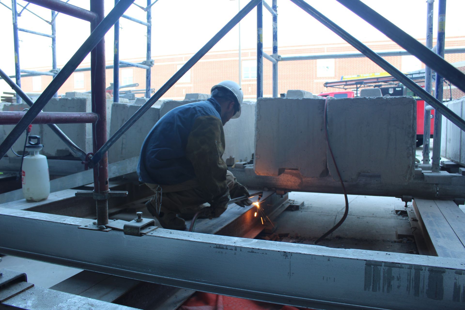 An Empire Services team member torch cuts part of steel beam. 