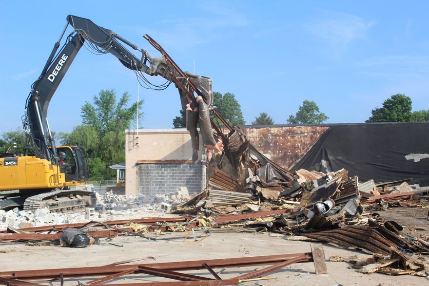 A deere excavator is demolishing a building