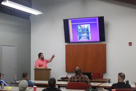 A man is giving a presentation in front of a group of people