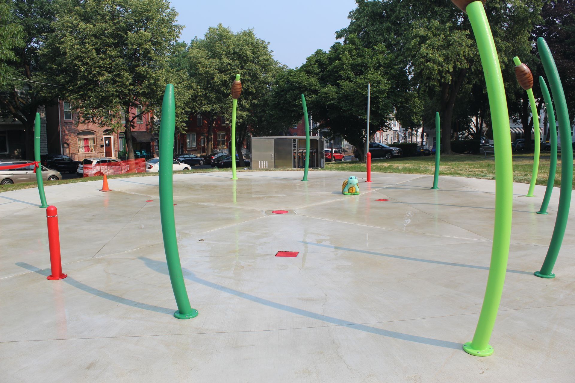 A water park with green and red pipes and trees in the background