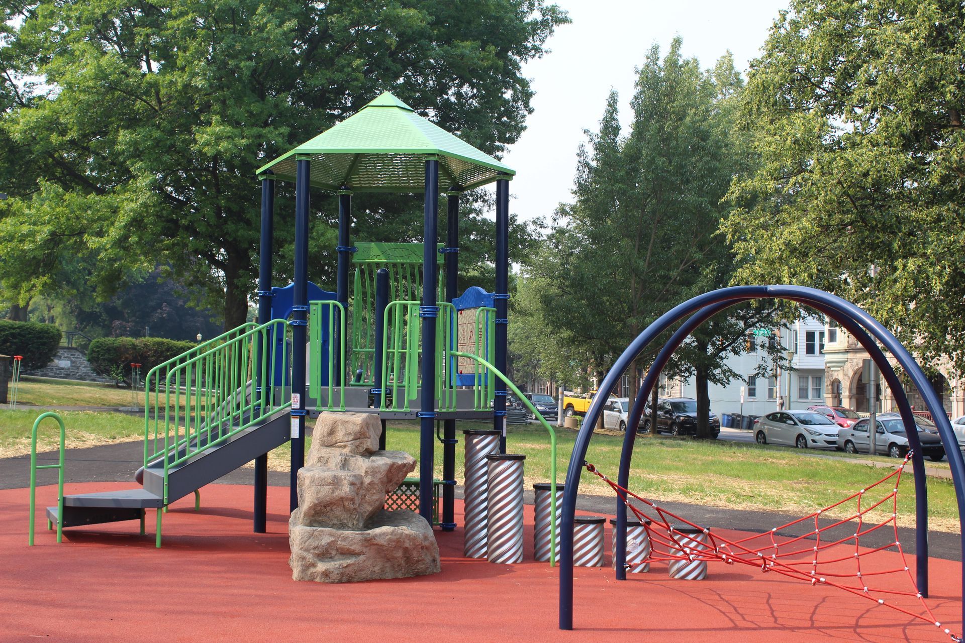 A playground with a green roof and a blue arch