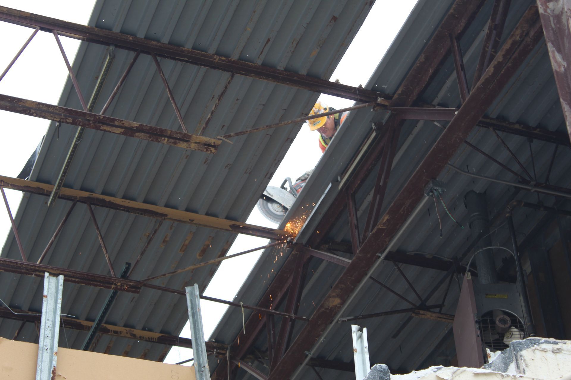 A man is welding the roof of a building