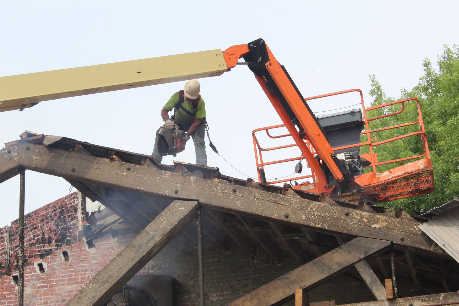 An Empire Services crew member uses a circular saw to cut up the wooden roof.