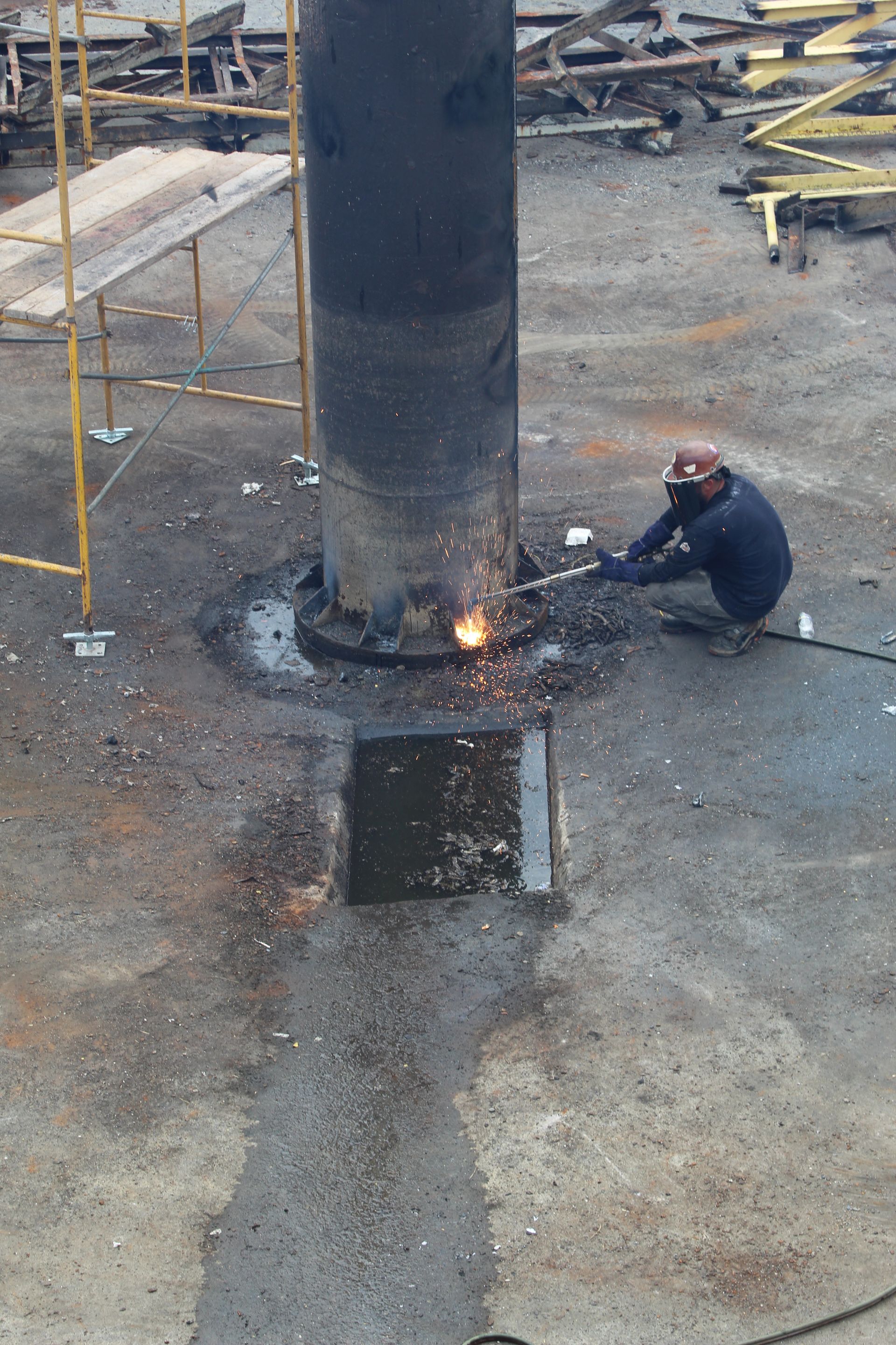 An Empire Services crew member torch cuts the center column with precision.