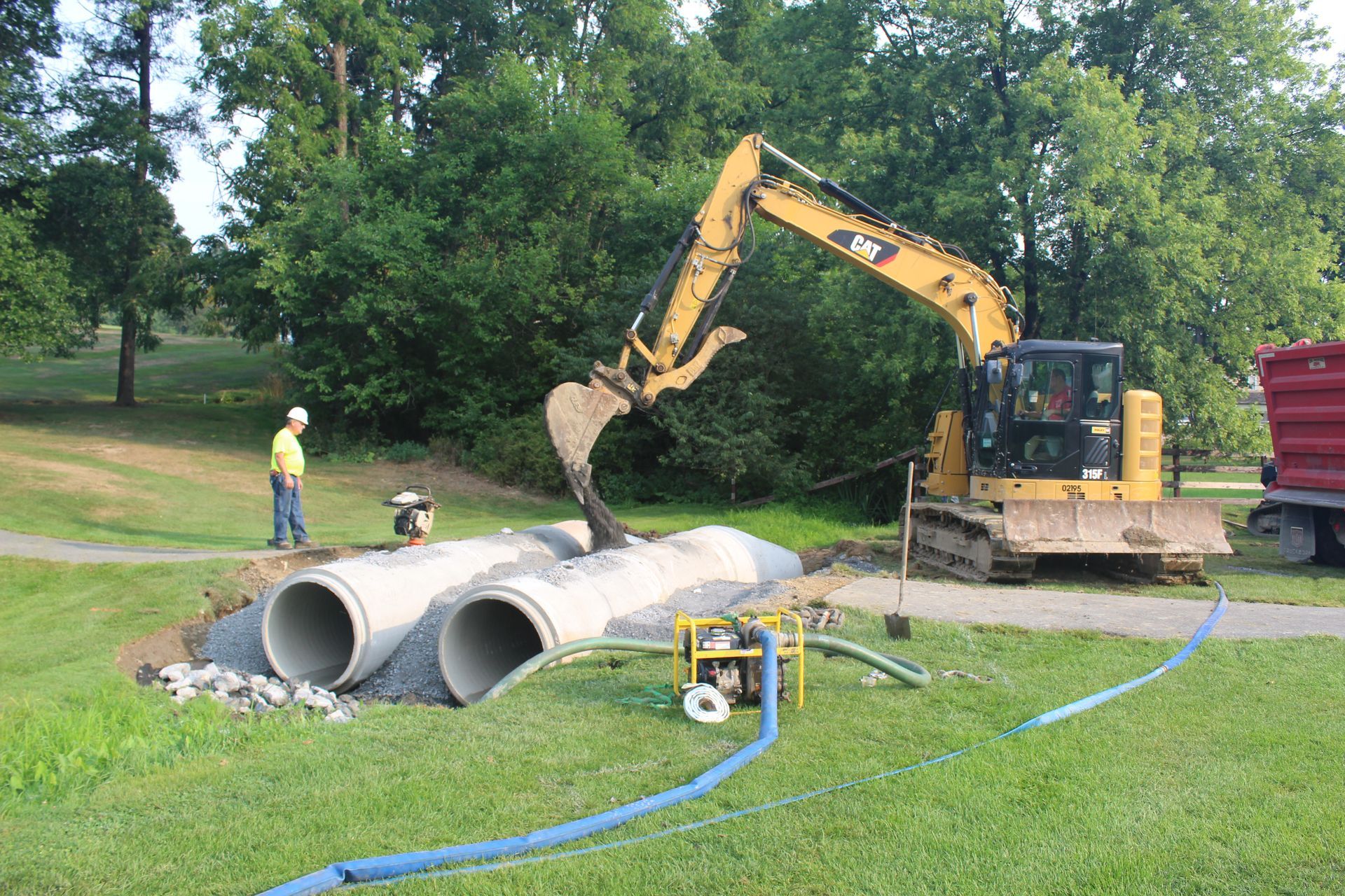 Concrete pipes in place and stone material is put on top of them. 
