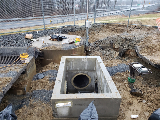 A hole in the ground with a pipe in it.