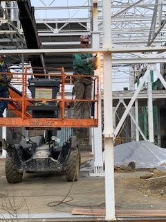 torch cutting support beams at a repurposed manufacturing site