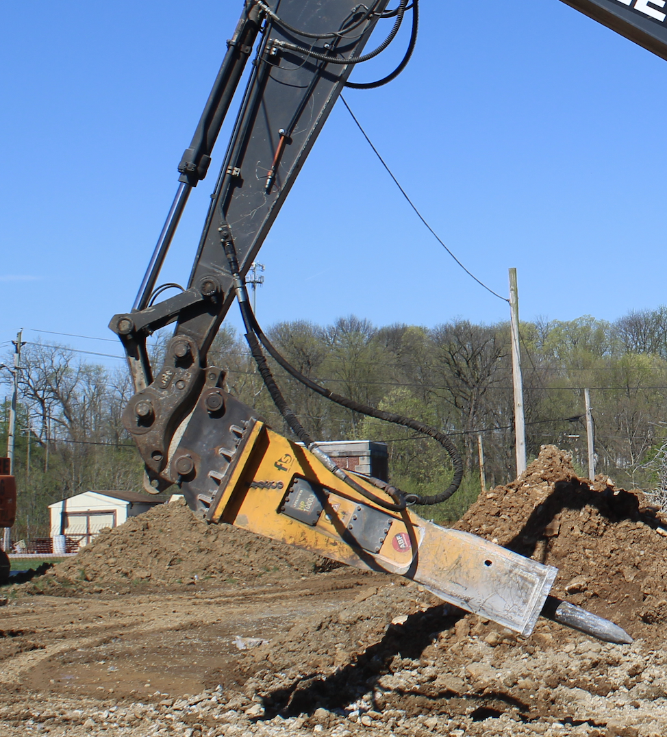 A large excavator with a hammer attached to it