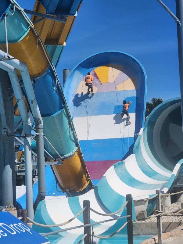 Crew working mid-installation on a blue multi-lane waterslide