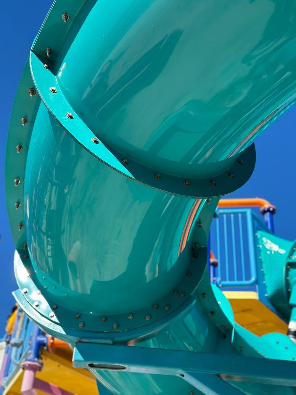 Water Slide Repair Service: A blue water slide with a blue sky in the background